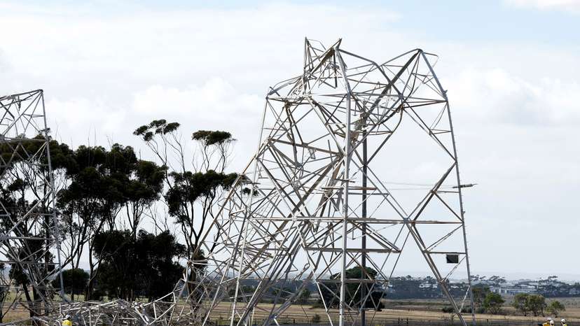 Workers inspect damaged transmission towers at Anakie
