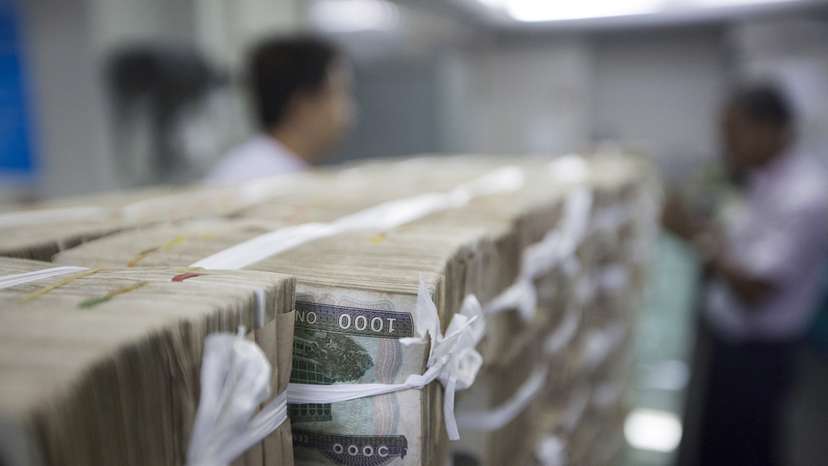 FILE PHOTO: Stacks of Myanmar kyat are seen on the counter before a client collects them, at a bank in Yangon, Myanmar
