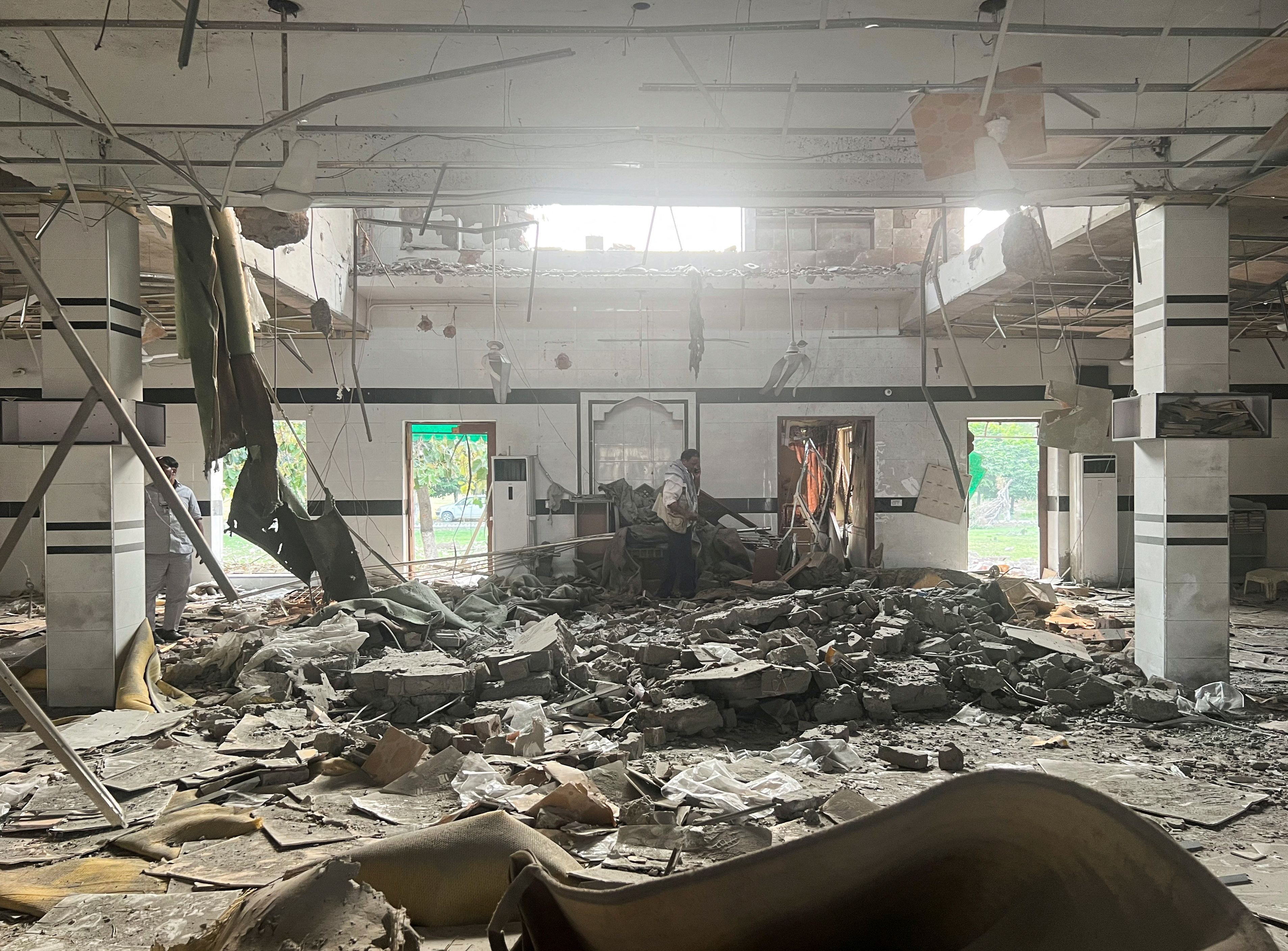 A man walks inside a mosque after it was hit by an Indian strike, in Muridke