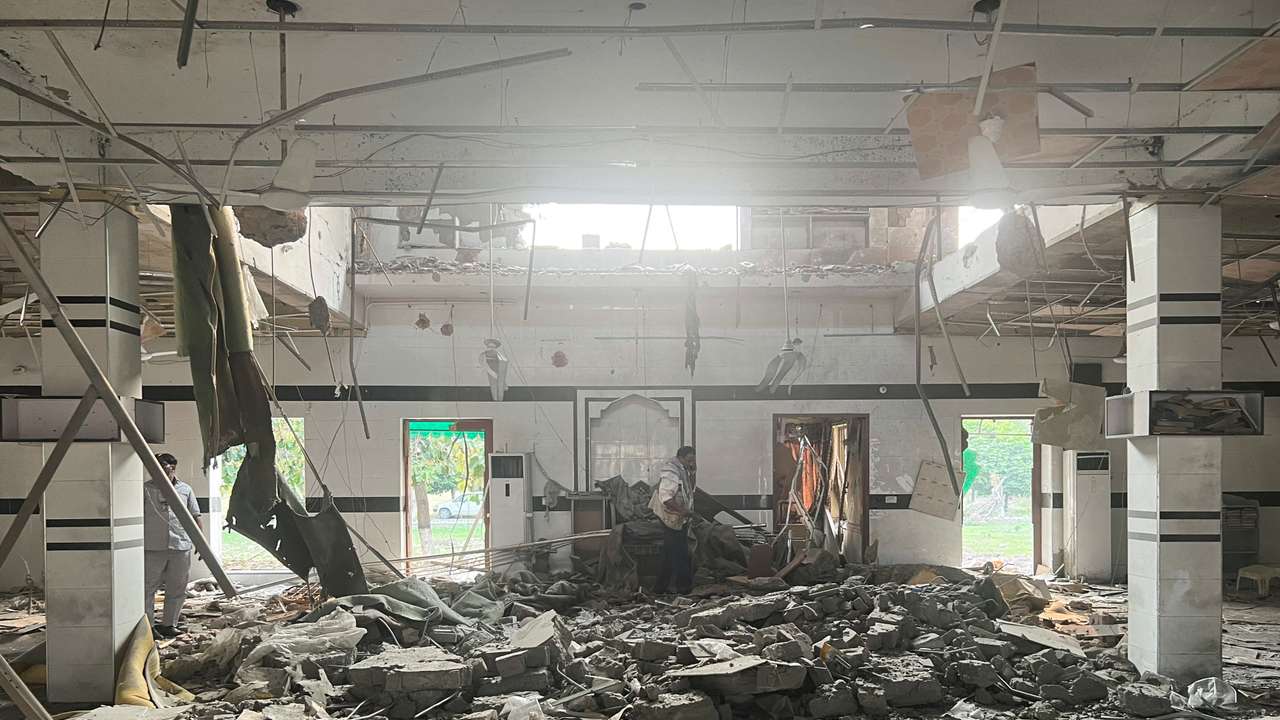 A man walks inside a mosque after it was hit by an Indian strike, in Muridke