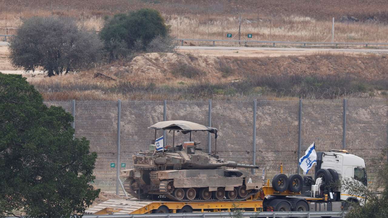 An Israeli tank is transported along the Israeli side of the border with Gaza, reflecting the ongoing military operations in the region amid escalating tensions. REUTERS/Amir Cohen.