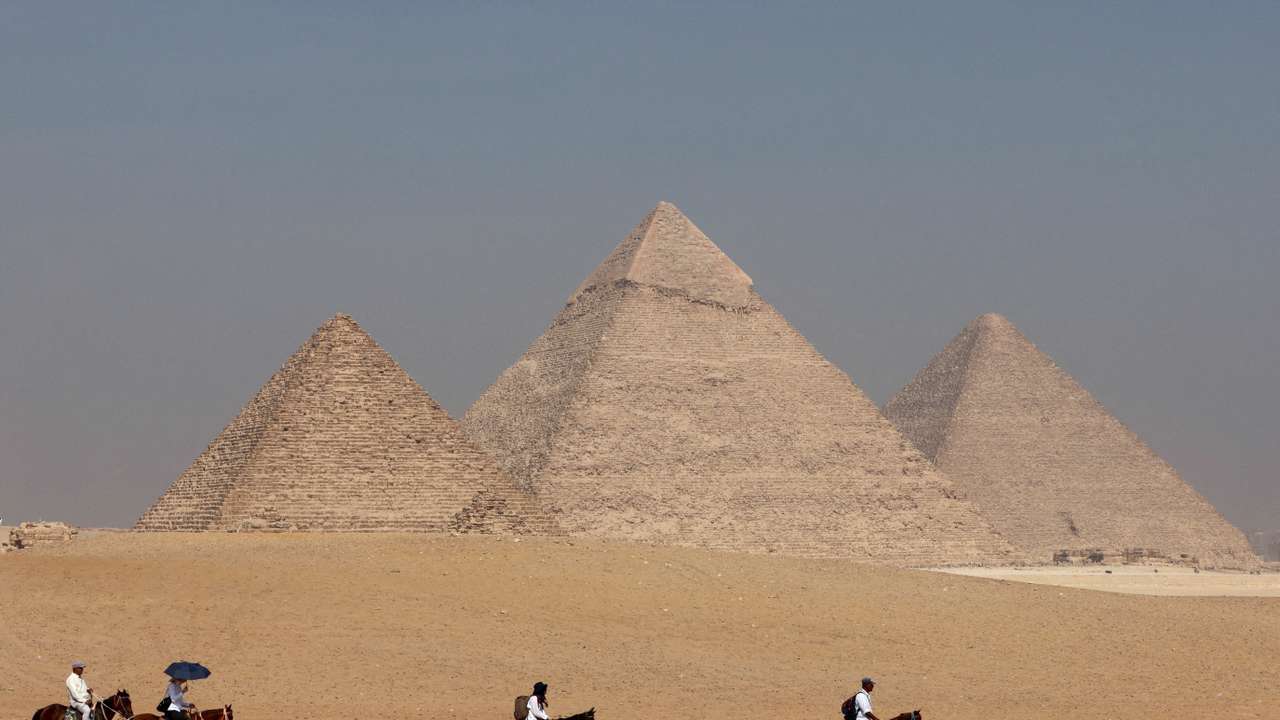 FILE PHOTO: Tourists ride horses in front of the Great Pyramid of Giza