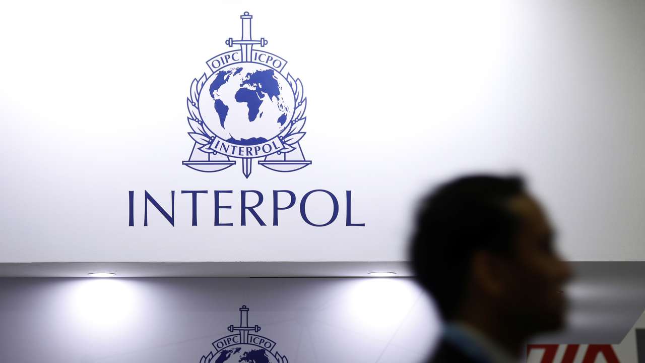 FILE PHOTO: A man passes Interpol signages at Interpol World in Singapore