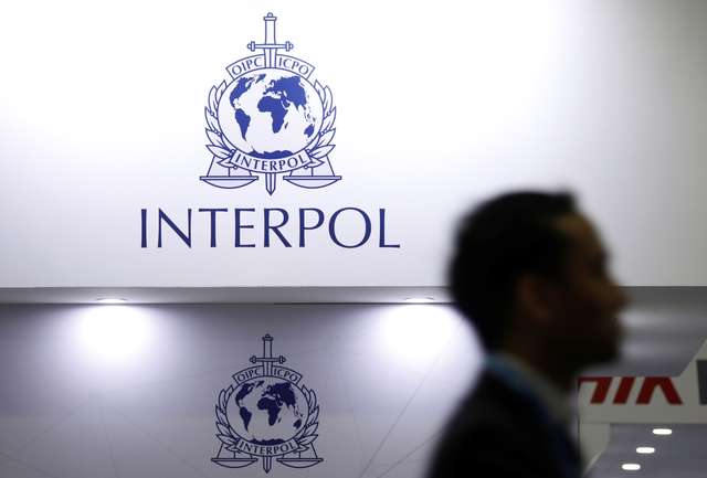 FILE PHOTO: A man passes Interpol signages at Interpol World in Singapore