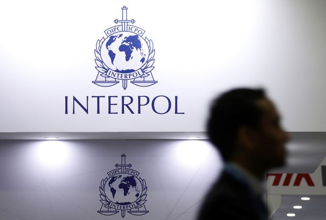 FILE PHOTO: A man passes Interpol signages at Interpol World in Singapore