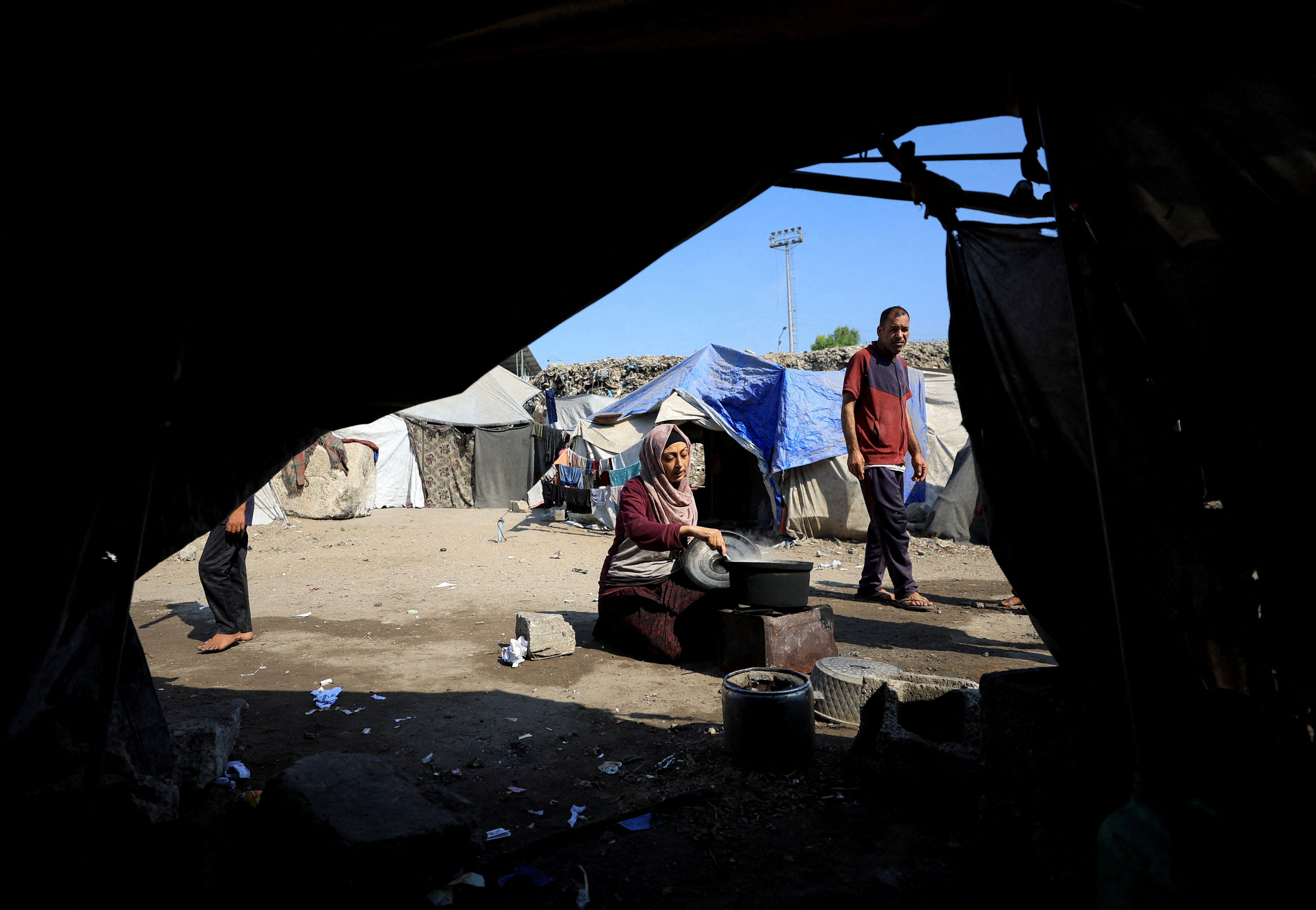 Displaced Palestinians who have not received humanitarian aid survive on leftover food, in Gaza