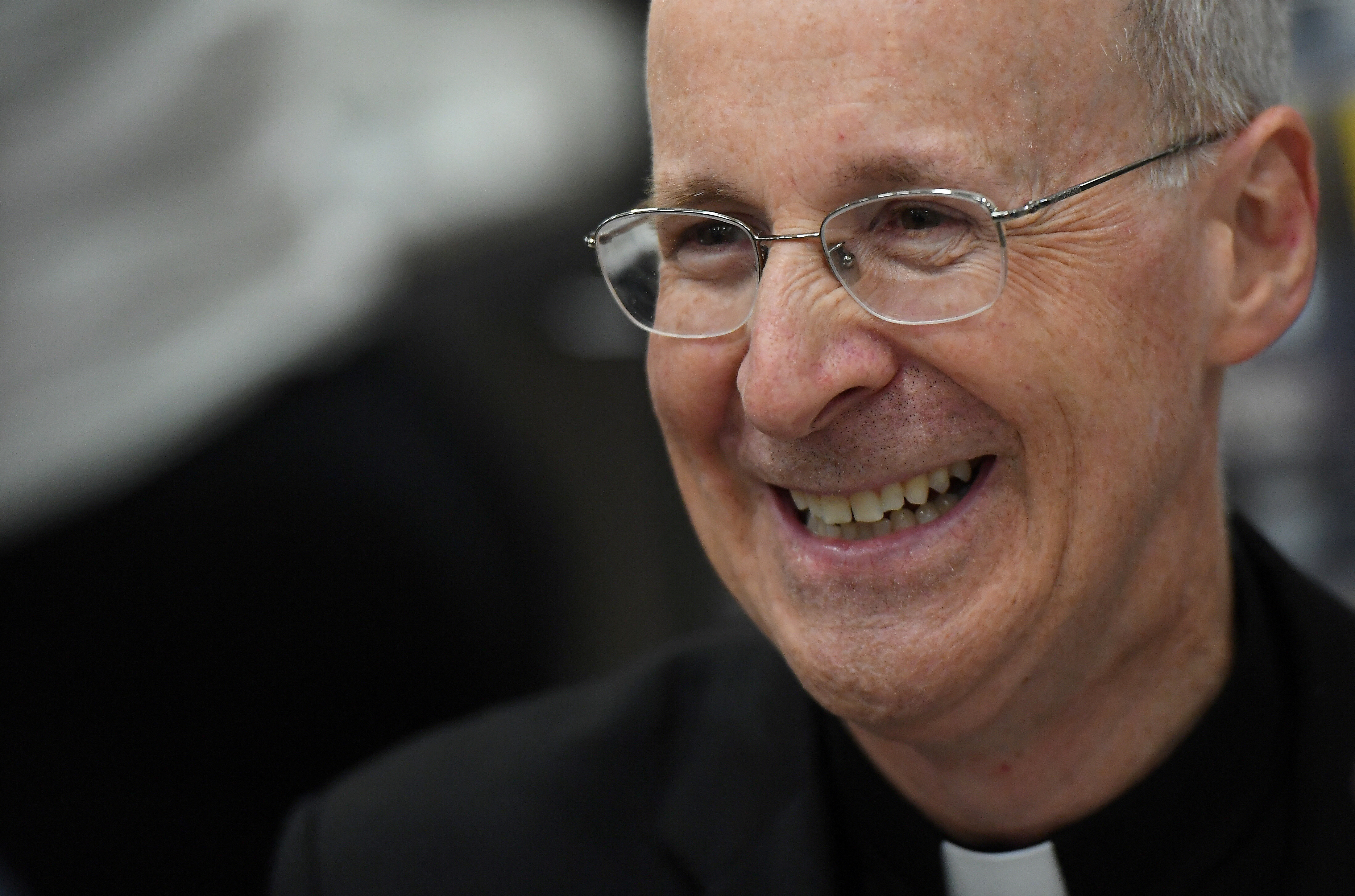 FILE PHOTO: Jesuit priest father James Martin of the U.S. smiles as he signs copies of his book at the Pastoral Congress at the World Meeting of Families in Dublin, Ireland