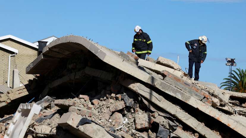 FILE PHOTO: Rescuers work to rescue construction workers trapped under a building that collapsed in George