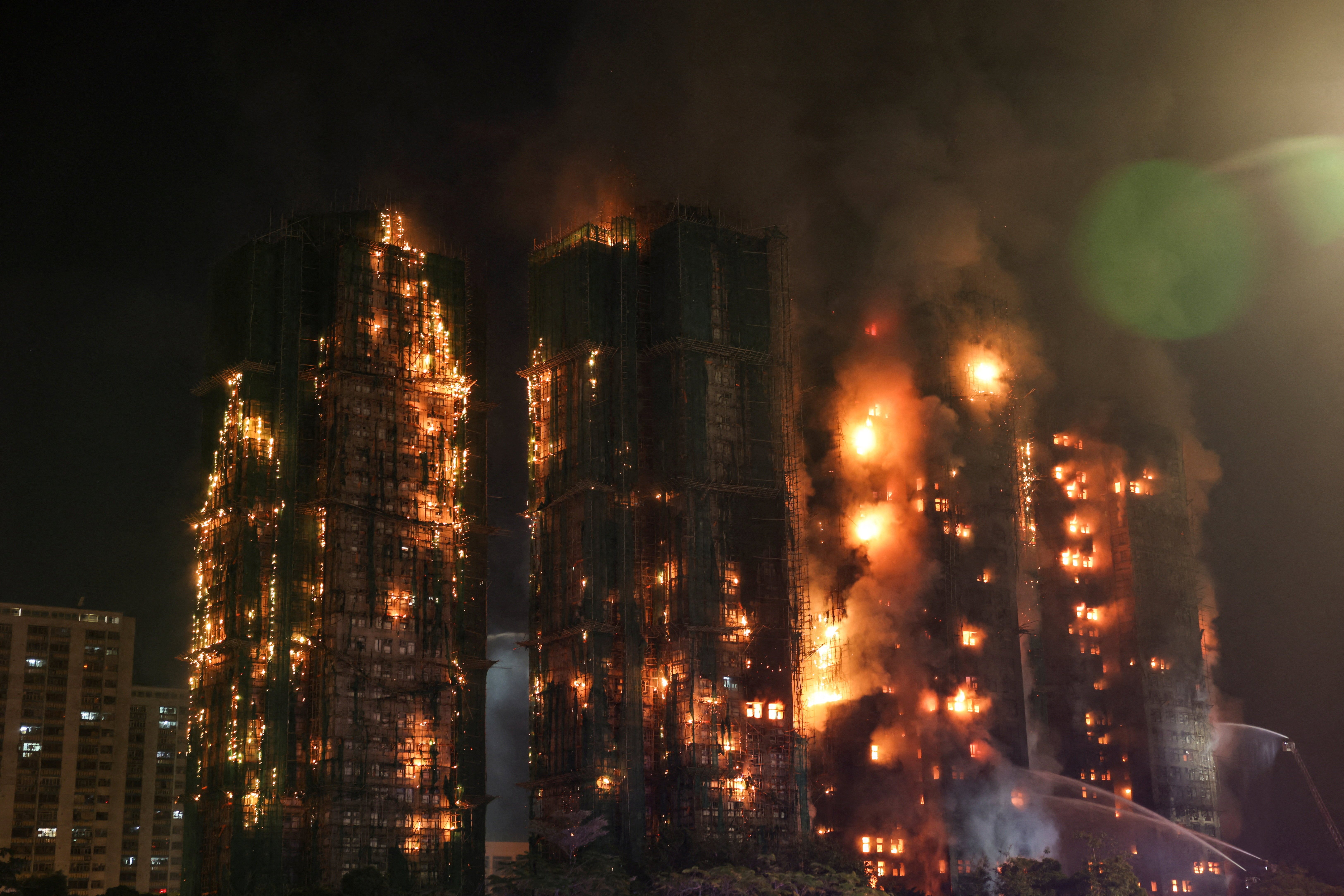 FILE PHOTO: Flames and thick smoke rise from the Wang Fuk Court housing complex during a deadly fire, in Hong Kong