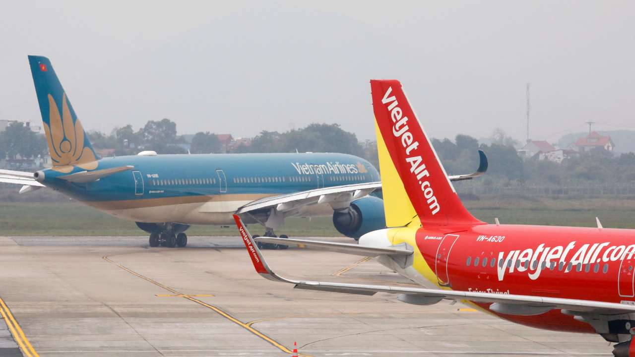 FILE PHOTO: Aircraft of the national flag carrier Vietnam Airlines taxis past a Vietjet aircraft at Noi Bai airport in Hanoi