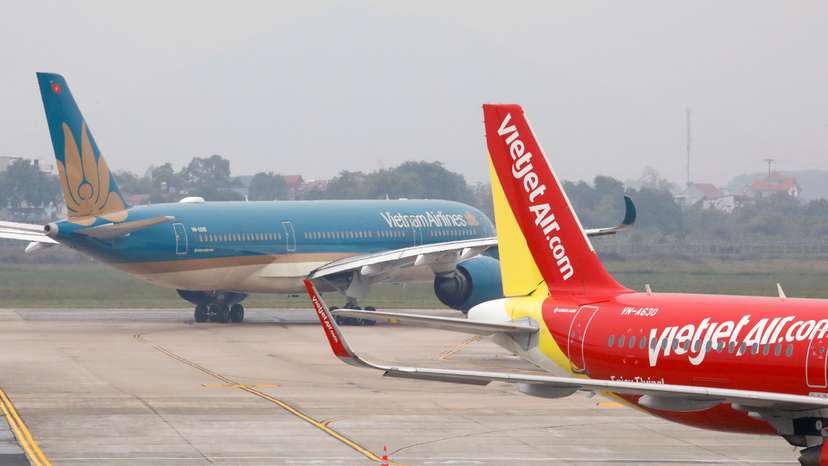 FILE PHOTO: Aircraft of the national flag carrier Vietnam Airlines taxis past a Vietjet aircraft at Noi Bai airport in Hanoi