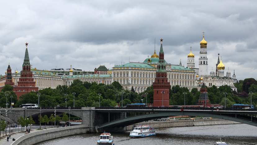 Vessels sail along a river near Moscow's Kremlin