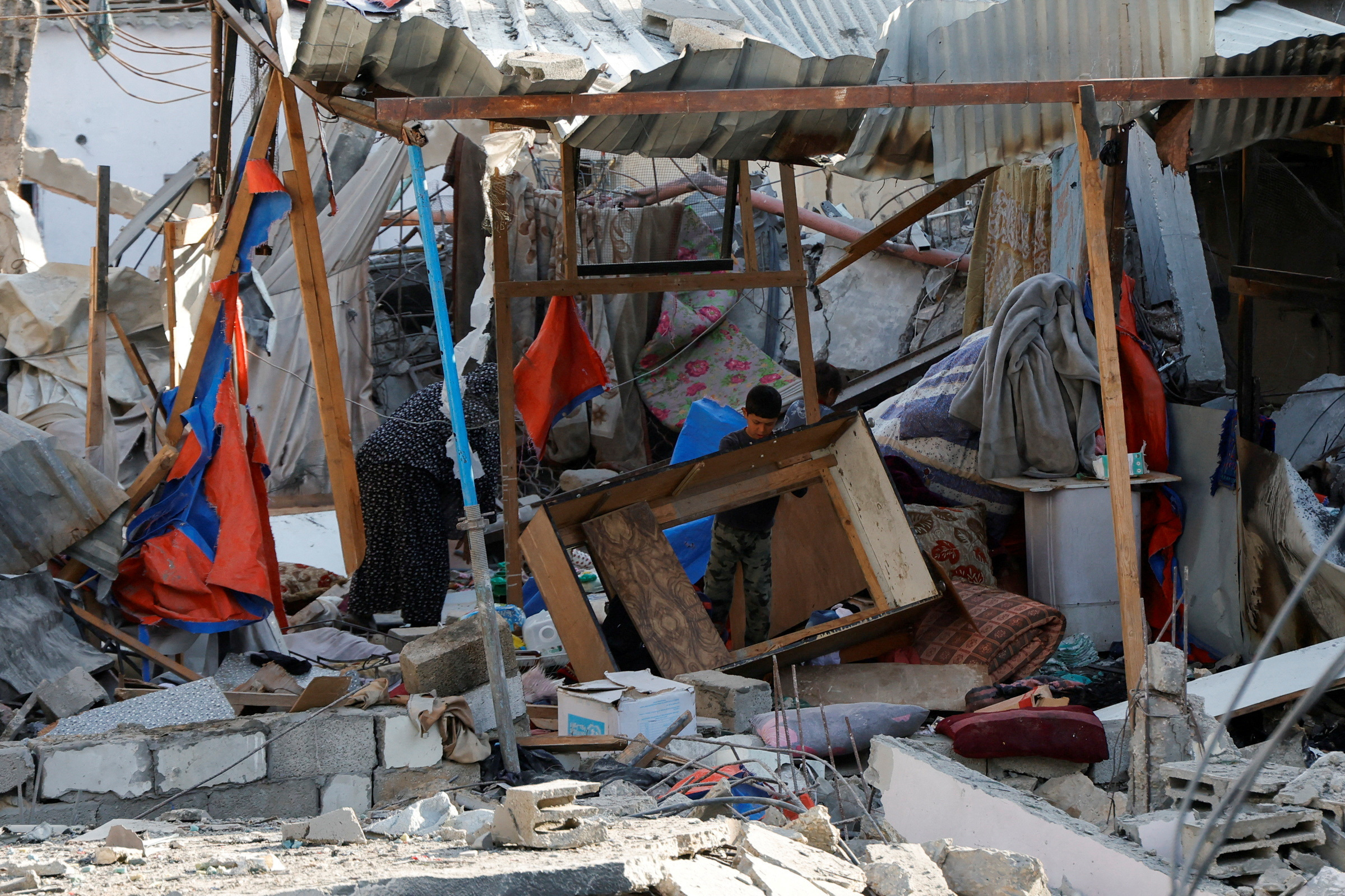 Palestinians inspect the site of an Israeli strike on a house, in Khan Younis in the southern Gaza Strip