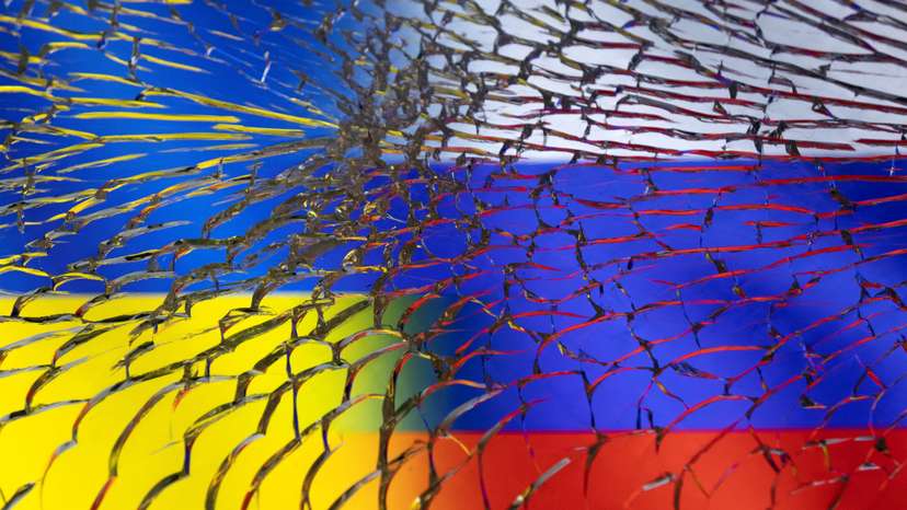 Illustration shows Ukraine and Russian flags through broken glass