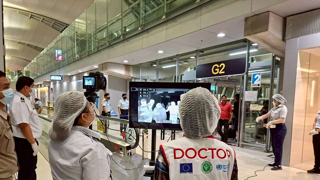 Airport health authorities wearing protective masks monitor passengers from international flights arriving at Suvarnabhumi International Airport