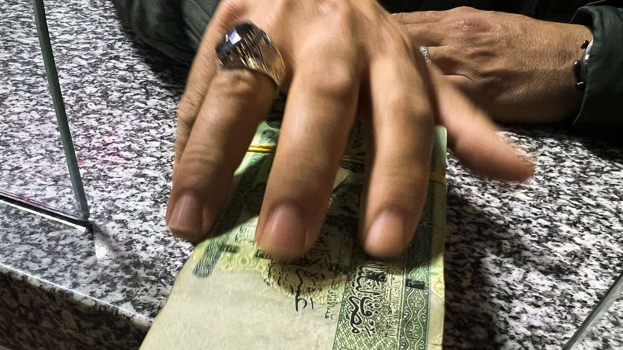 A man receives money from a bank employee in Misrata