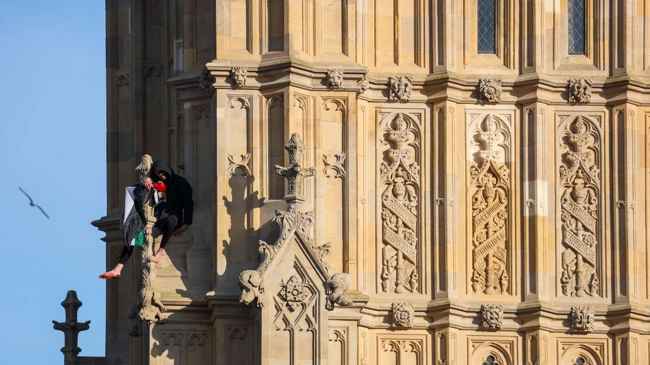 A man holding a Palestinian flag climbs Big Ben in London
