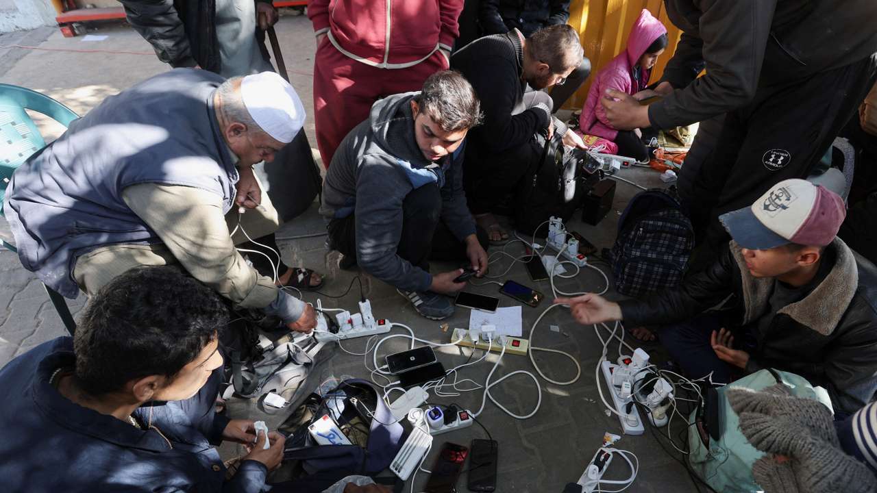 Palestinians charge their devices outside the Emirati hospital in Rafah