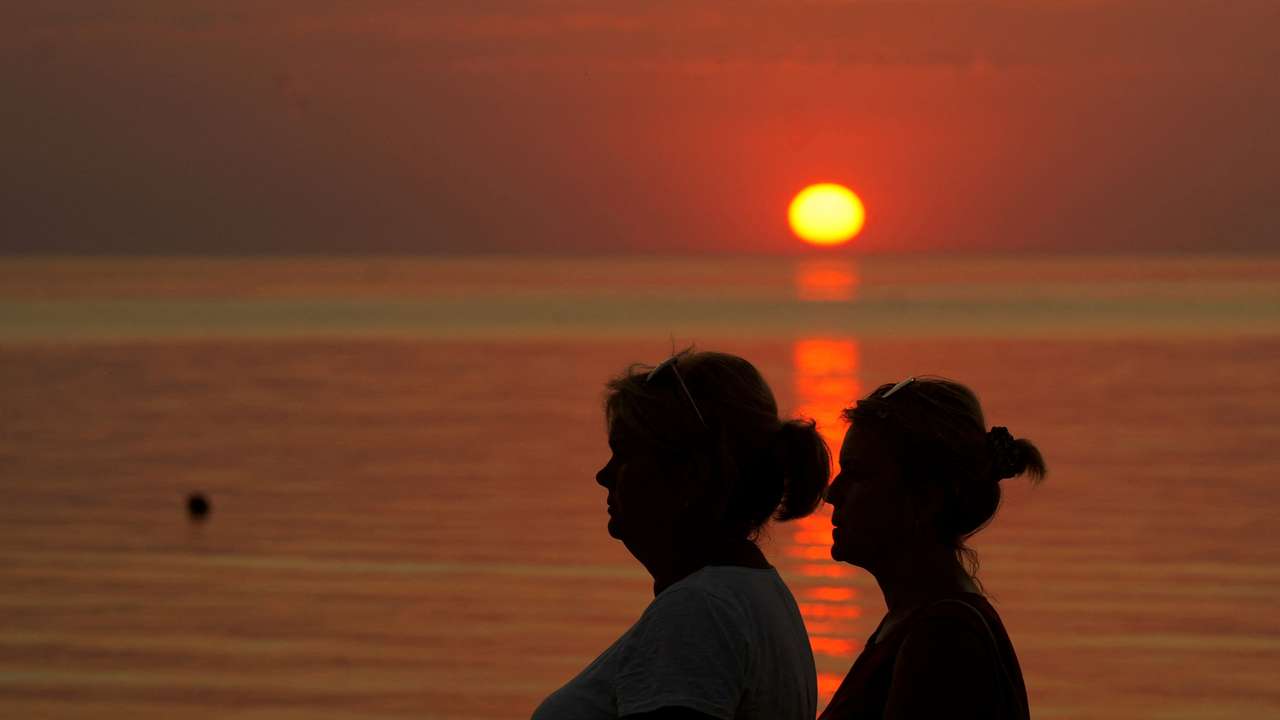 FILE PHOTO: People watch sunset on the seaside in Saulkrasti, Latvia