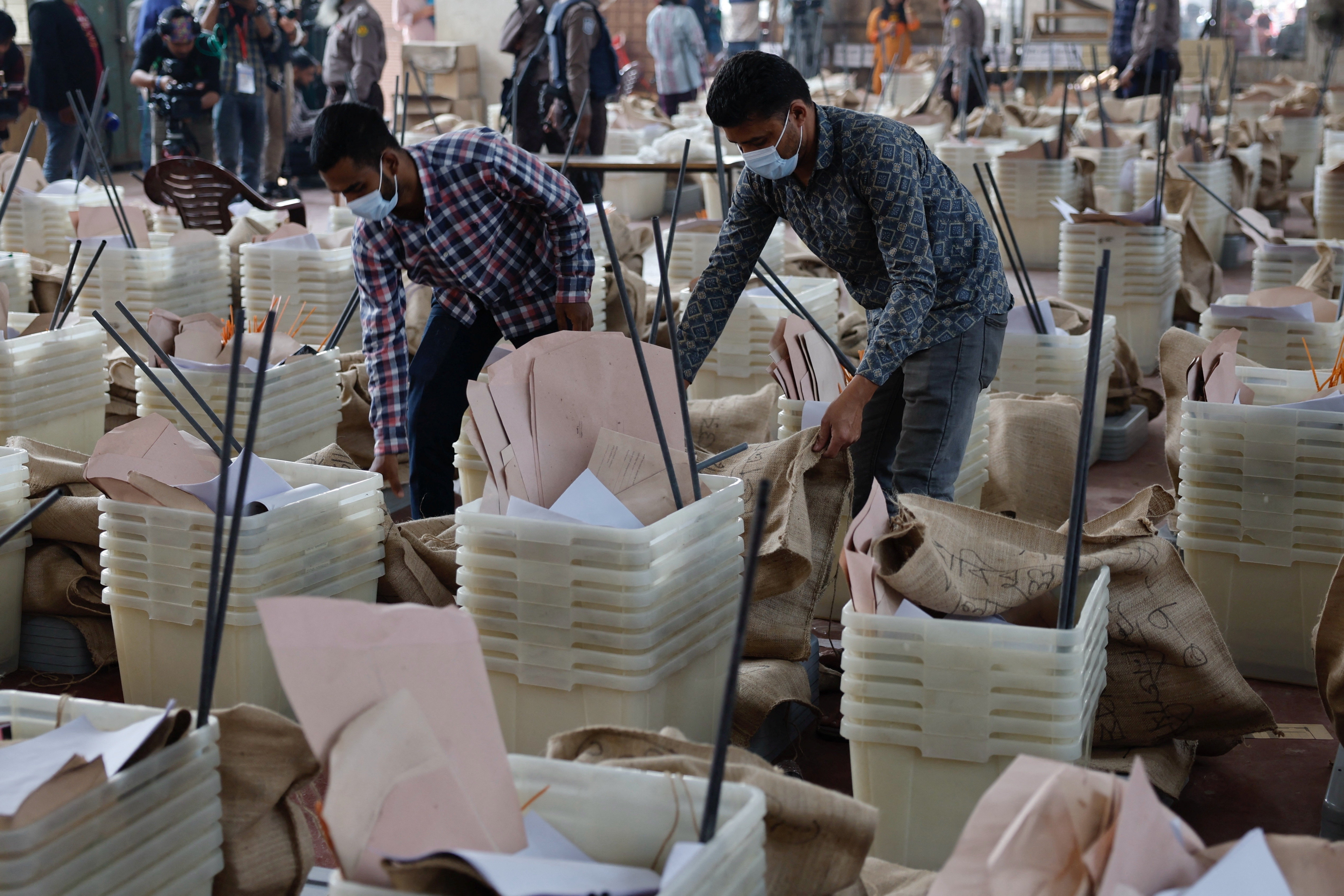 Officials give a final check before dispatching the ballot boxes to voting centres, a day ahead of the national election in Dhaka