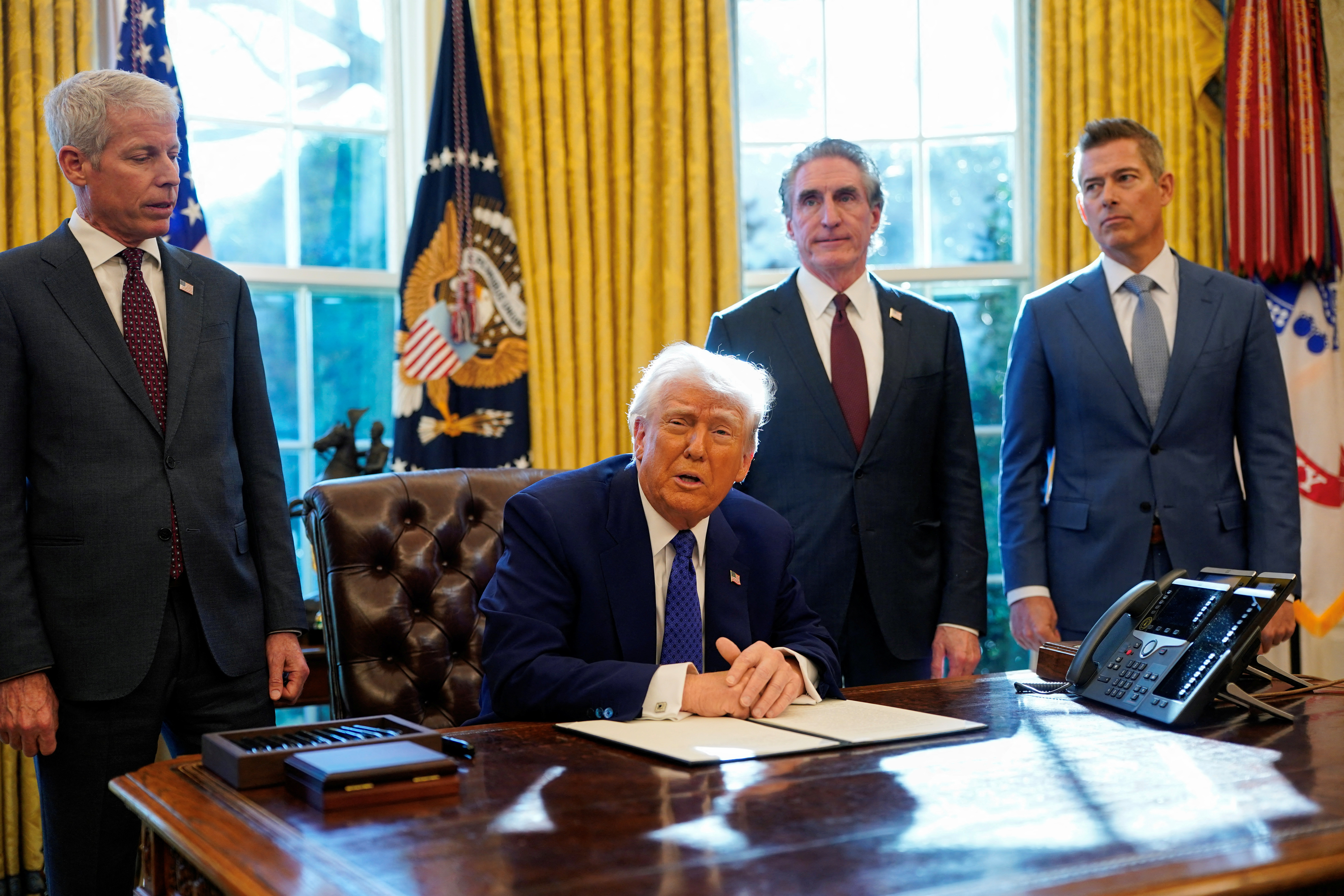 U.S. President Donald Trump signs an executive order in the Oval Office at the White House in Washington, D.C.