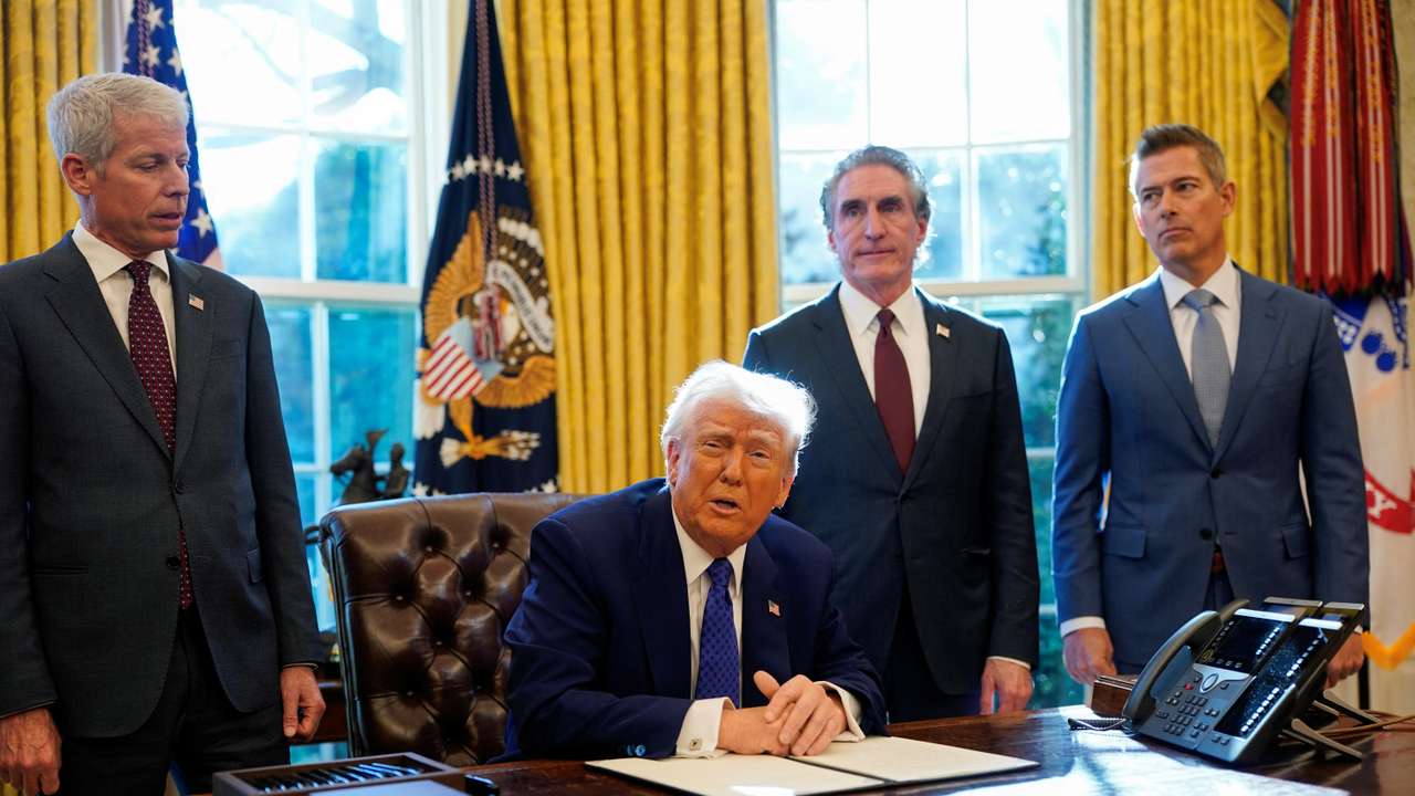 U.S. President Donald Trump signs an executive order in the Oval Office at the White House in Washington, D.C.