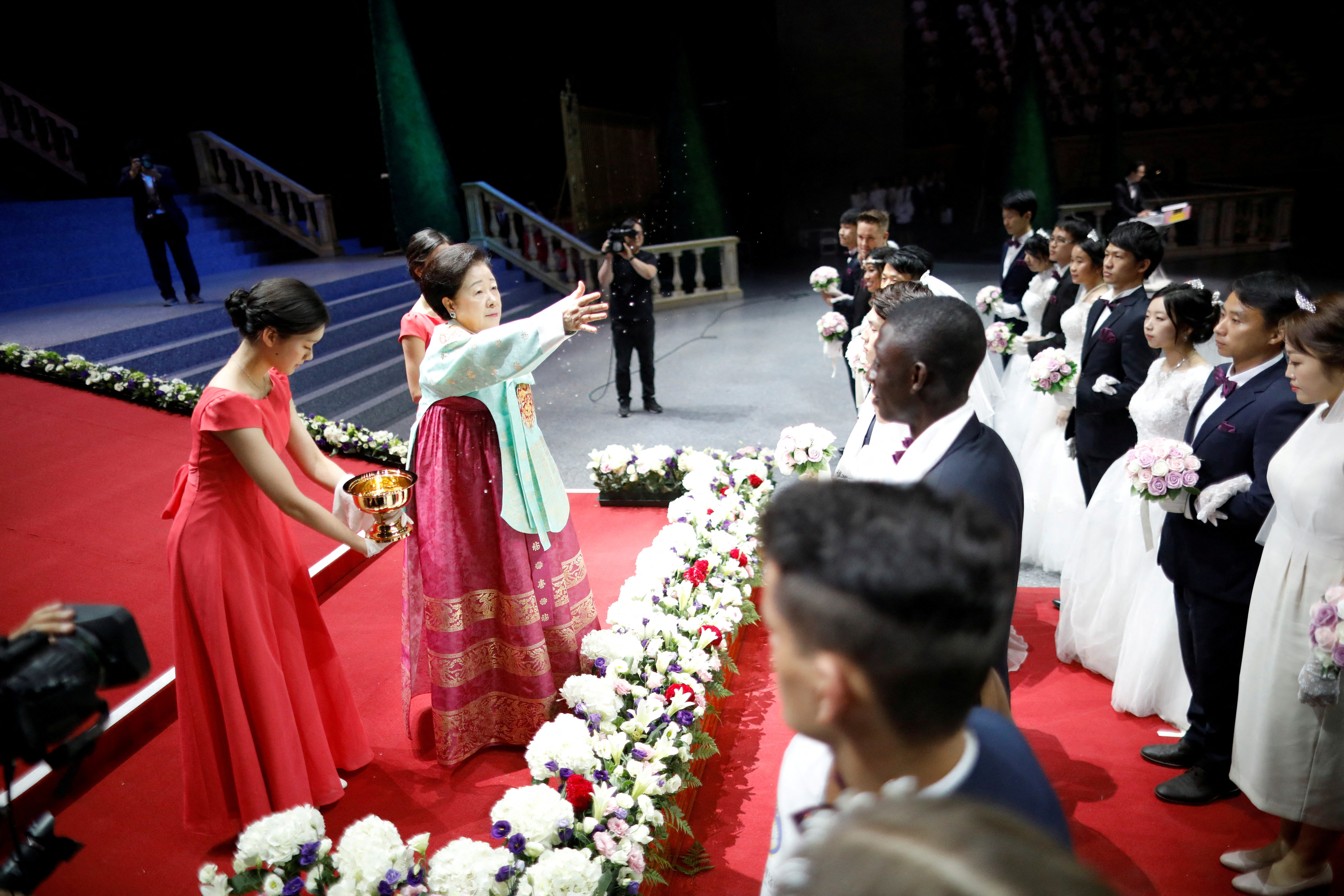 FILE PHOTO: Han Hak-ja, widow of Evangelist Reverend Moon Sun-myung, sprays holy water to bless couples during a mass wedding ceremony of the Unification Church at Cheongshim Peace World Centre in Gapyeong