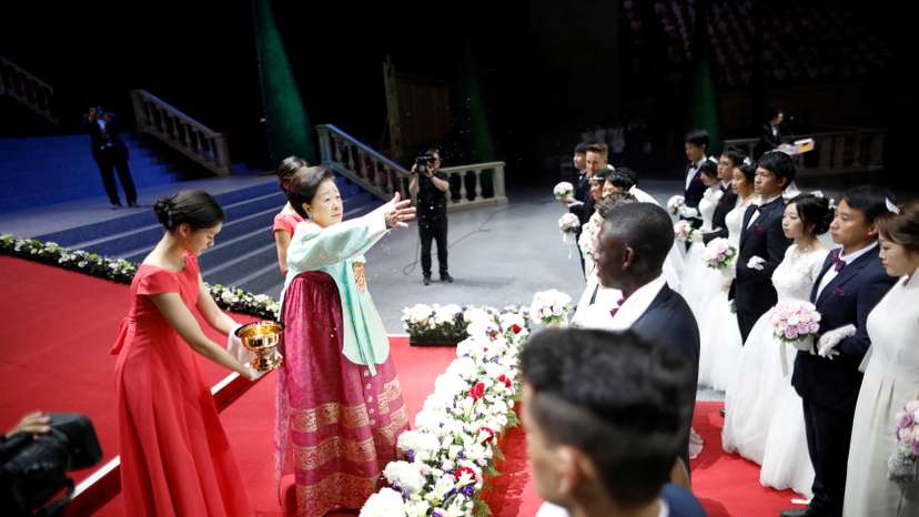 FILE PHOTO: Han Hak-ja, widow of Evangelist Reverend Moon Sun-myung, sprays holy water to bless couples during a mass wedding ceremony of the Unification Church at Cheongshim Peace World Centre in Gapyeong