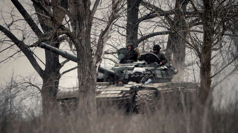 Ukrainian service members ride a tank in Donbas region