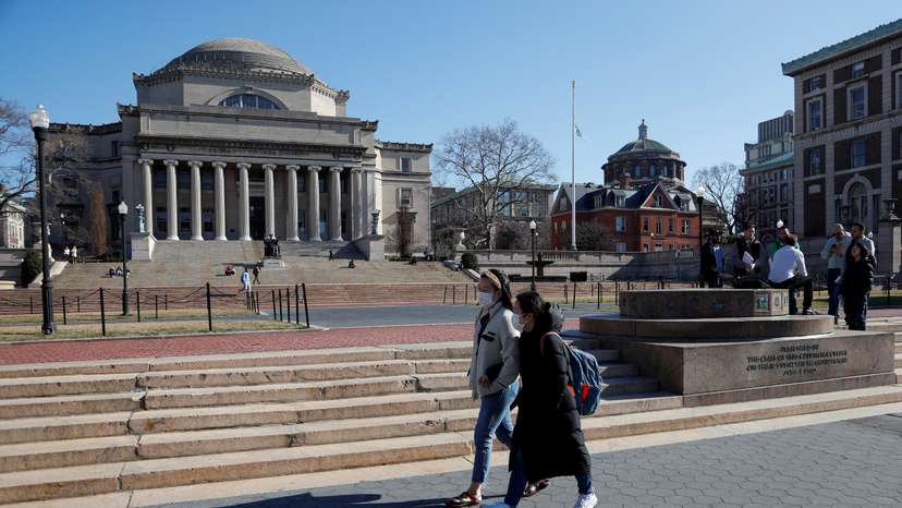 FILE PHOTO: People with face masks walk at Columbia University in New York City, where classes on Monday and Tuesday were suspended because someone on the campus was under quarantine from exposure to the coronavirus