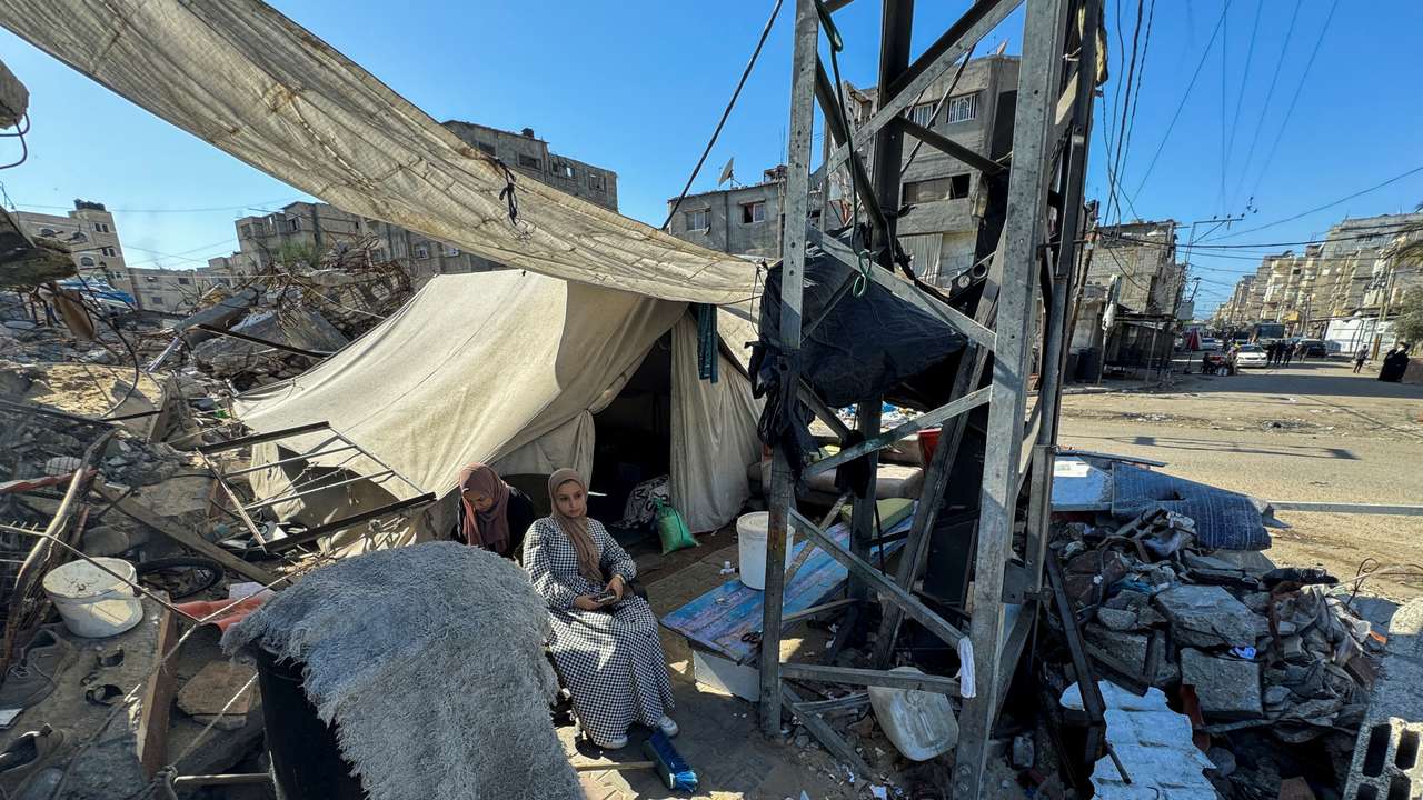 Displaced Palestinians, who fled their house due to Israel's military offensive, sit outside their tent, in Rafah, in the southern Gaza Strip