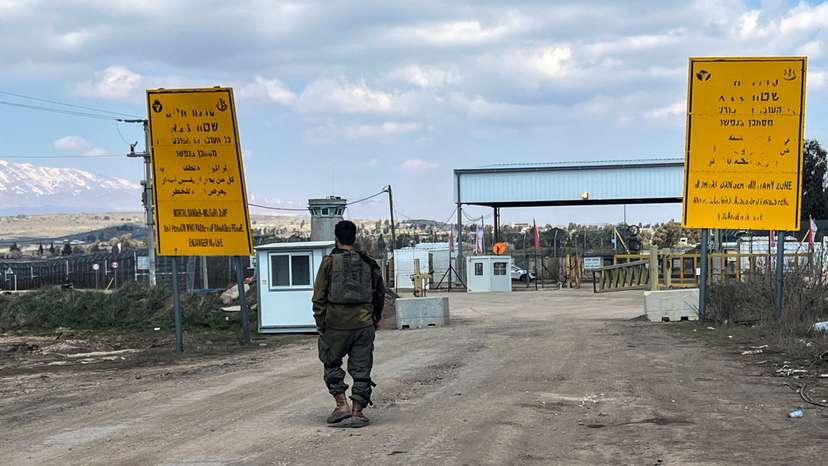 FILE PHOTO: An Israeli soldier walks by the fence of the ceasefire line by Syria and the Israeli-occupied Golan Heights, at Quneitra crossing in the Golan Heights