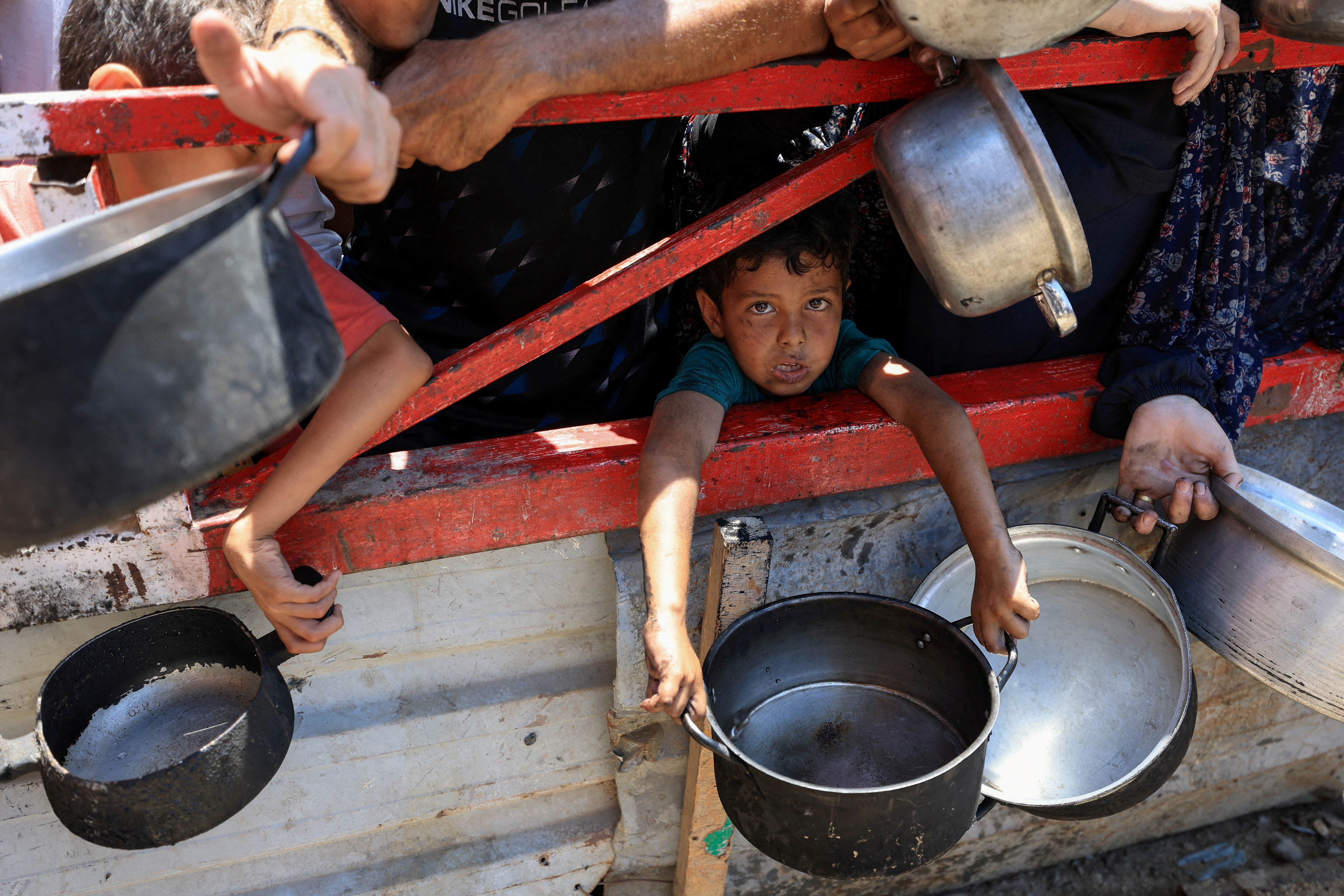 Palestinians gather to receive food from charity kitchen, in Gaza City