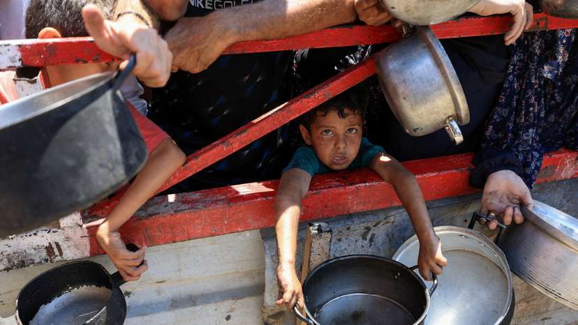 Palestinians gather to receive food from charity kitchen, in Gaza City