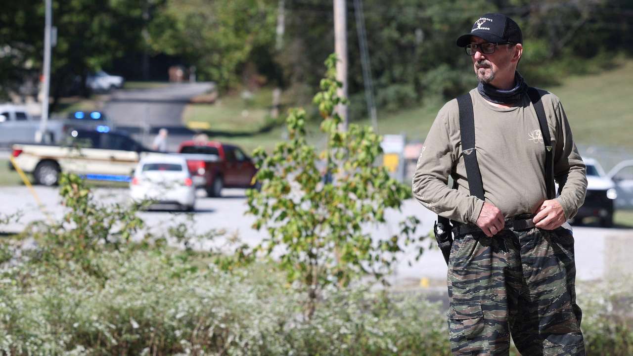 Law enforcement officers guard a gate outside the Accurate Energetic Systems military explosives plant in Bucksnort