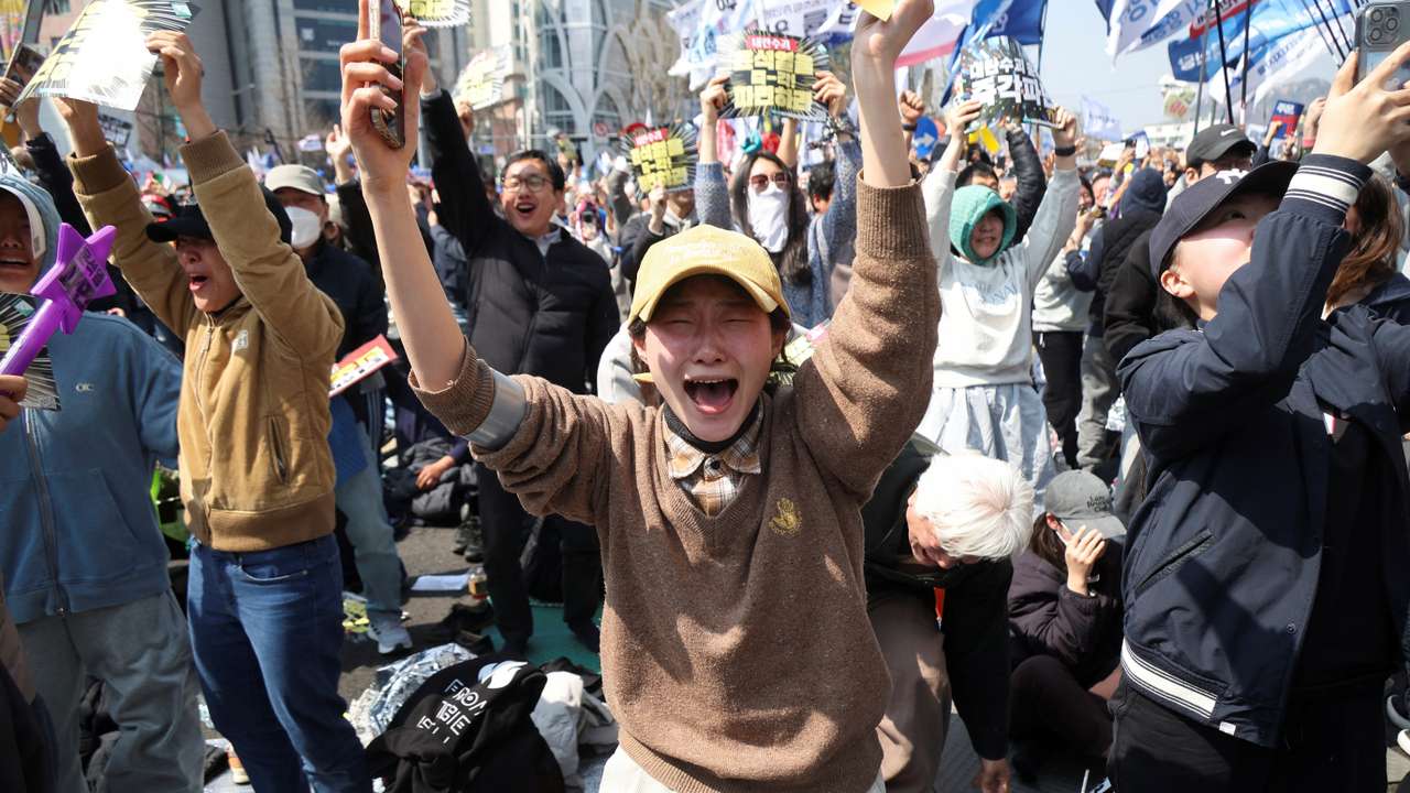 People celebrate after President Yoon Suk Yeol's impeachment was accepted, near the Constitutional Court in Seoul, South Korea