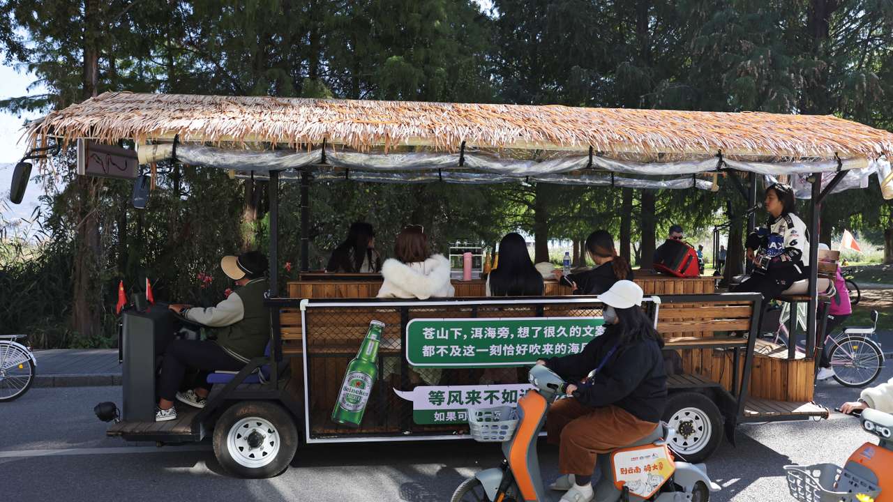 Man sings for customers touring the Erhai lake on a sightseeing bus, in Dali
