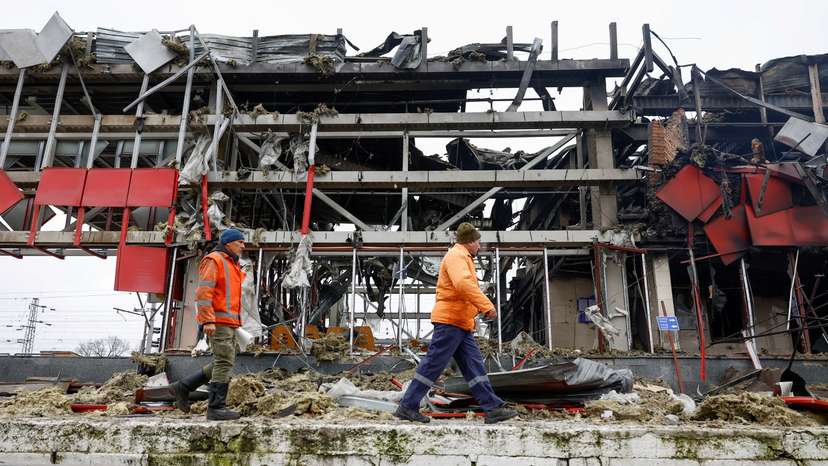 FILE PHOTO: Railway employees walk next to a railway station building hit during Russian missile and drone strikes in the town of Fastiv, Ukraine