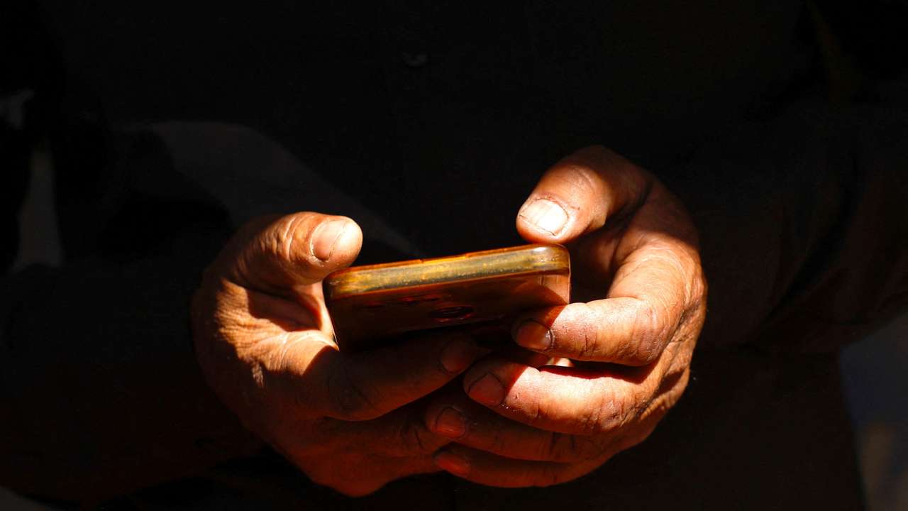 FILE PHOTO: A man uses his mobile in New Delhi