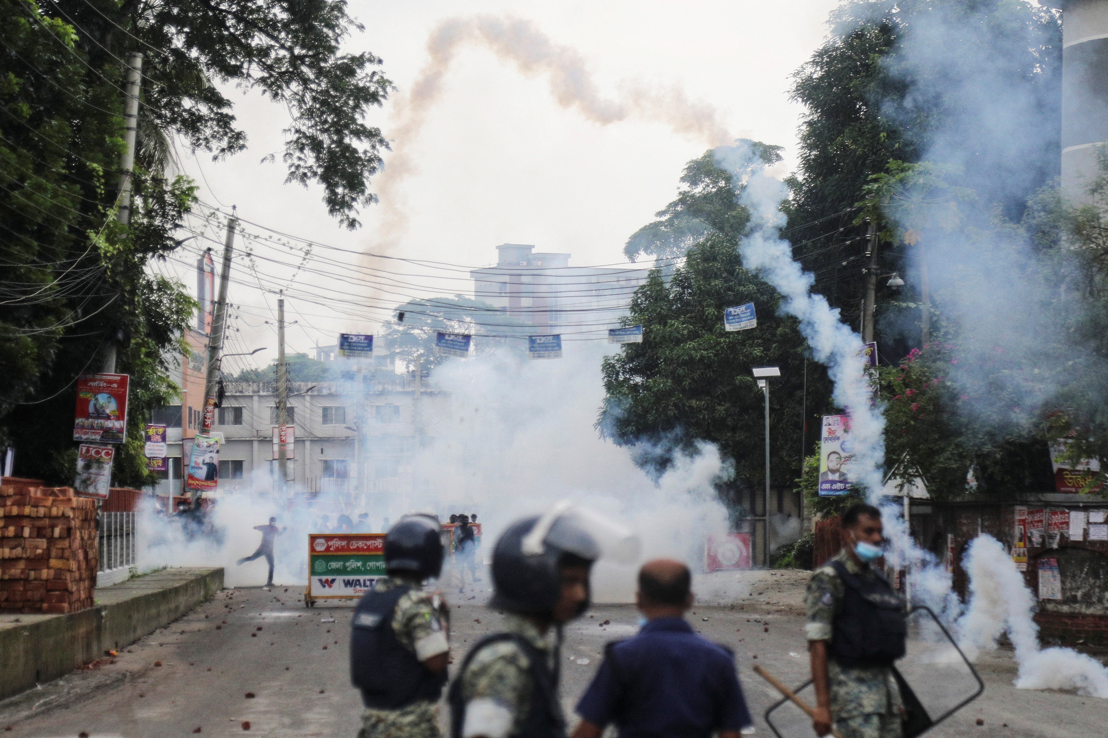 Security forces throw tear gas cans and sound grenades to disperse the Awami League supporters following a clash during the National Citizen Party rally, in Gopalganj
