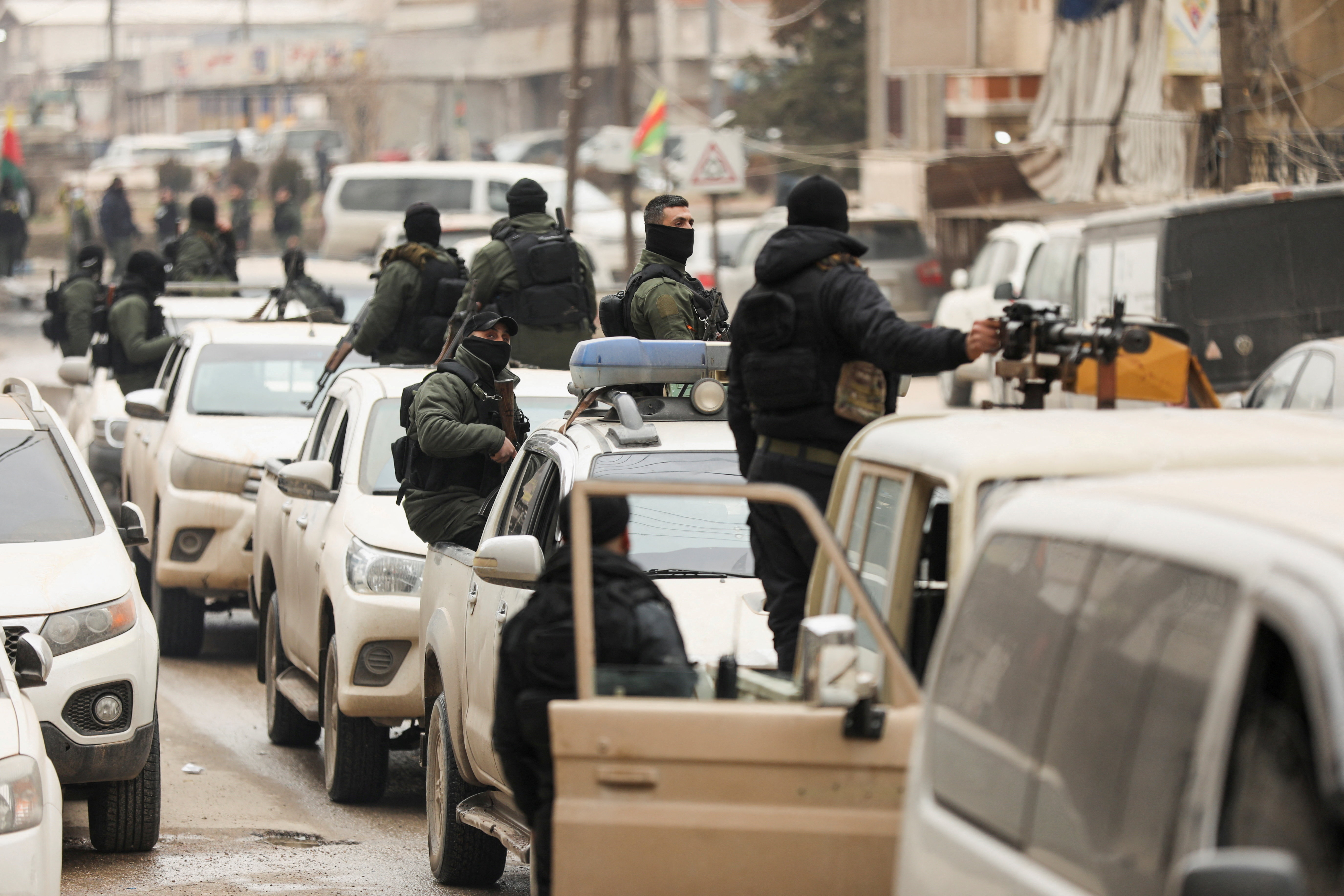 Members of the Kurdish Internal Security Forces wait for the arrival of the security forces of the Syrian government in Qamishli