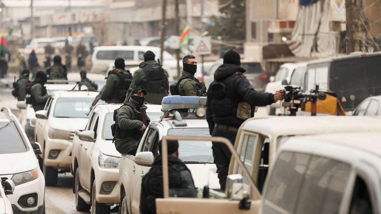 Members of the Kurdish Internal Security Forces wait for the arrival of the security forces of the Syrian government in Qamishli