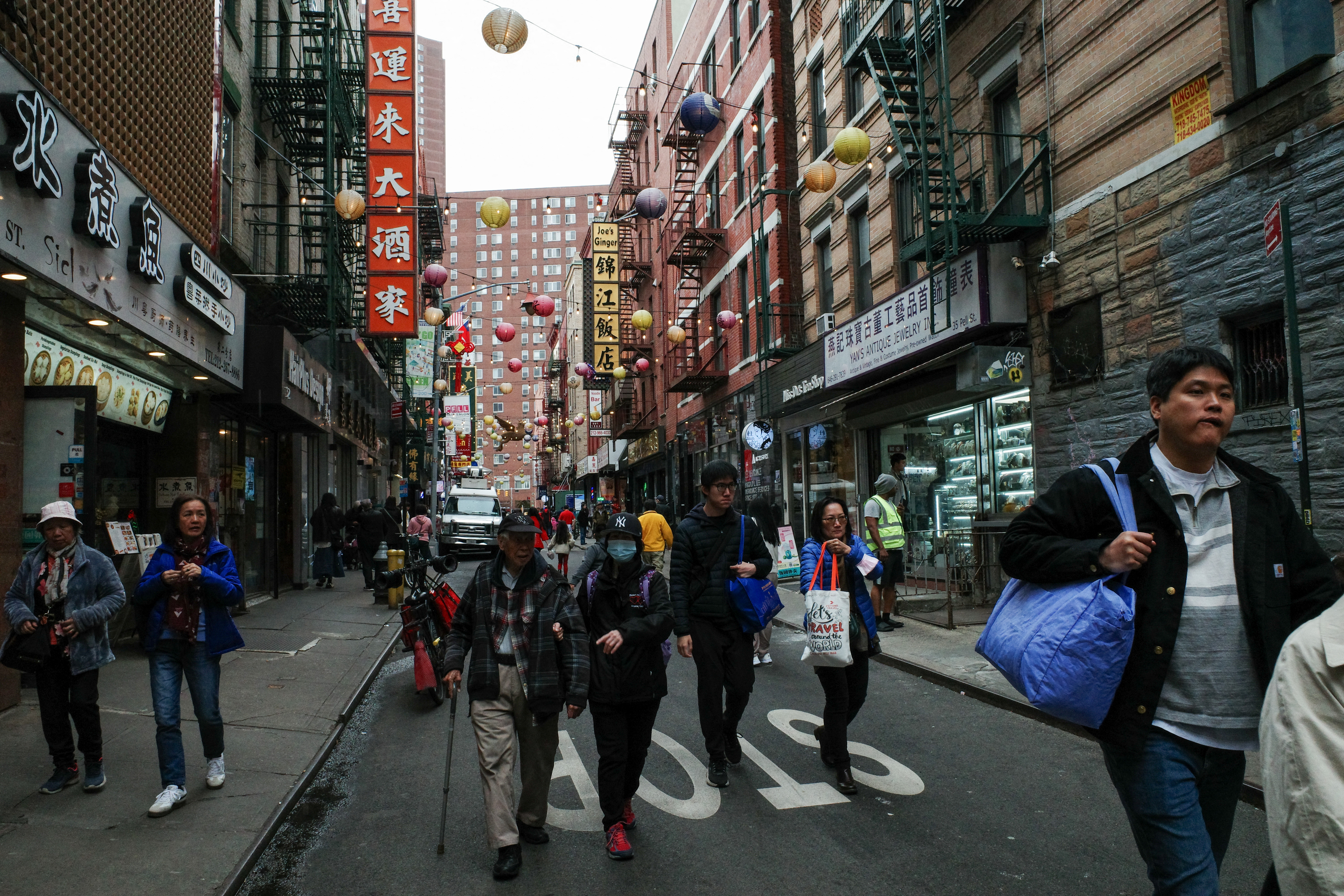 Tourists and pedestrians walk down Pell Street in the Chinatown neighborhood of Manhattan in New York City