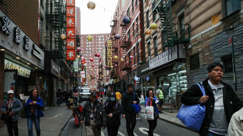 Tourists and pedestrians walk down Pell Street in the Chinatown neighborhood of Manhattan in New York City