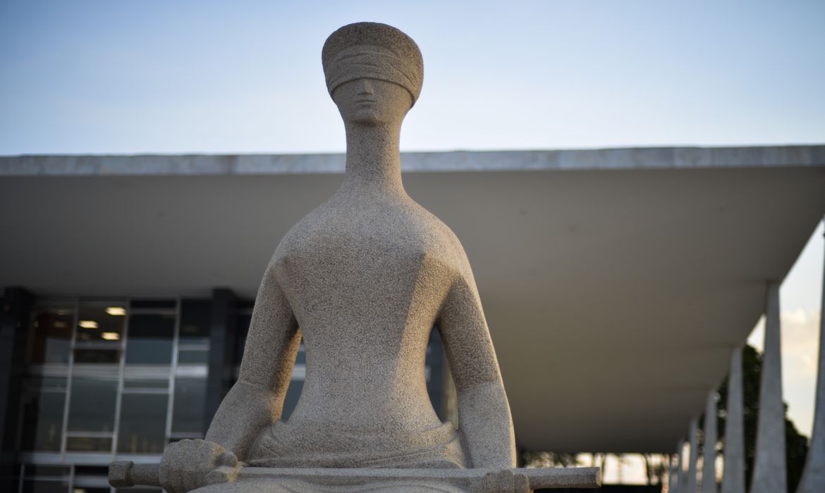 Imagem mostra estátua relacionada à Justiça situada na frente do prédio do STF, em Brasília