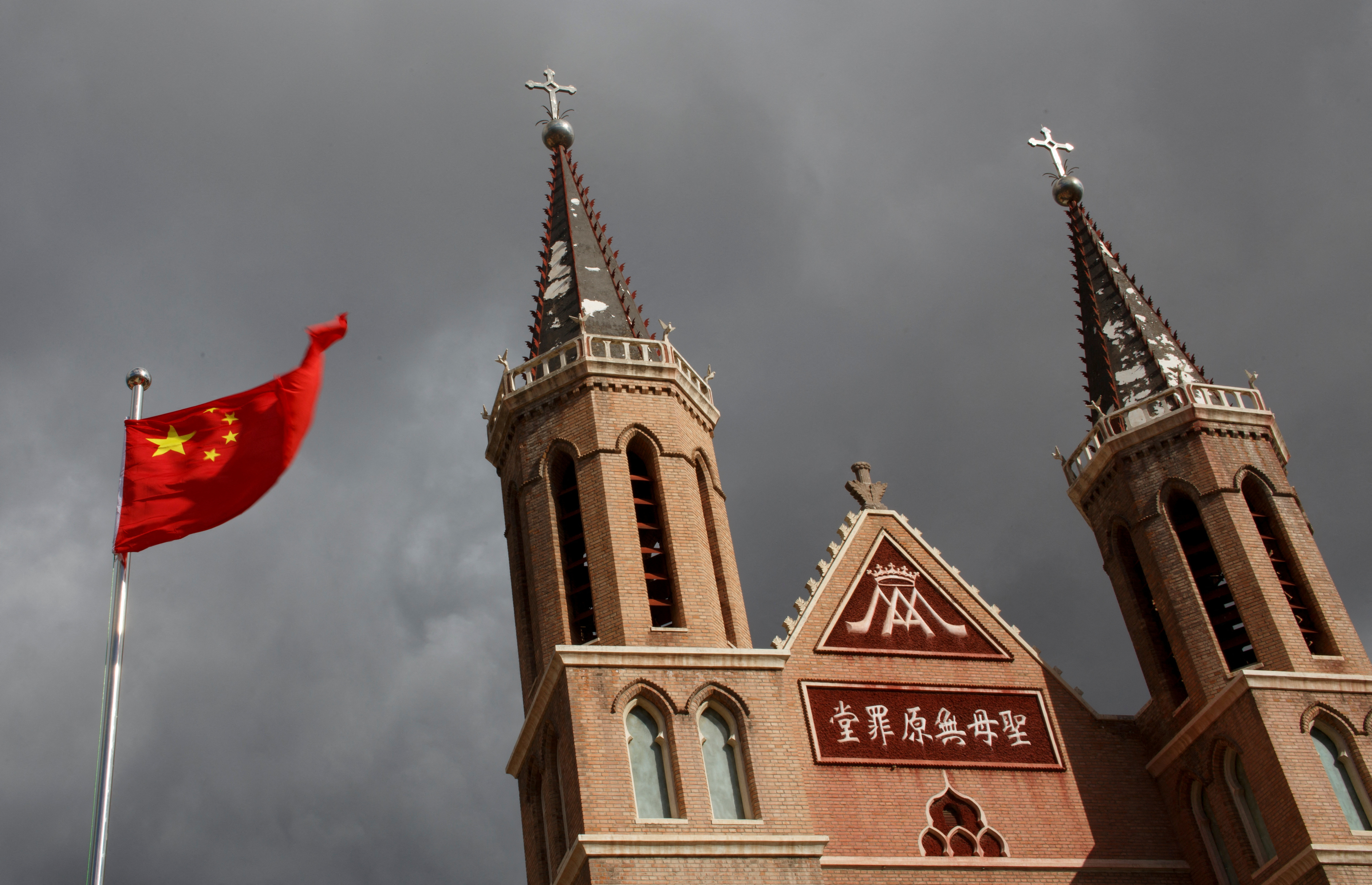 FILE PHOTO: The Chinese national flag flies in front of a Catholic underground church in the village of Huangtugang