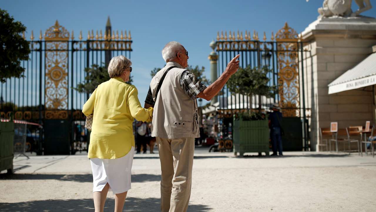 A couple of elderly people arrives at the Tuileries Garden in Paris