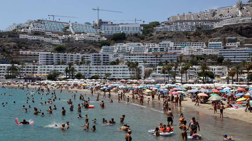 FILE PHOTO: Tourists bathe and sunbathe on the beach of Puerto Rico in the south of the island of Gran Canaria
