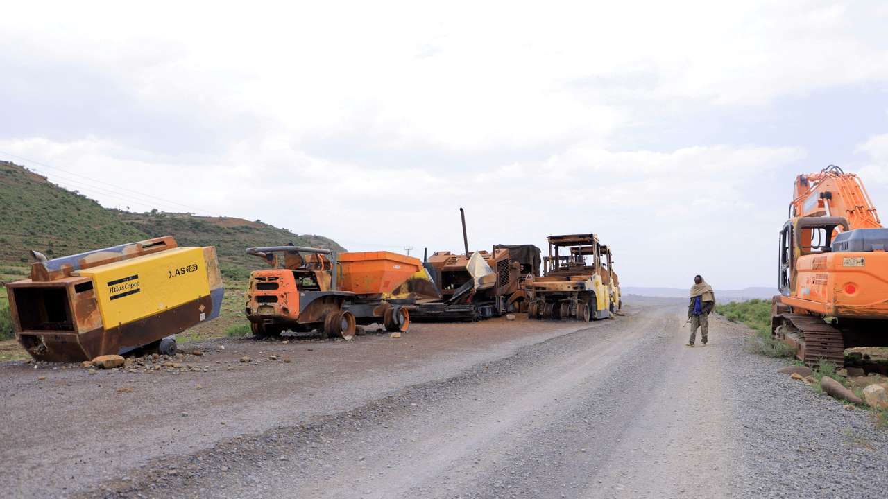 FILE PHOTO: A Tigrayan Militia member stands next to destroyed construction machineries during the fighting between the TPLF and ENDF on the outskirt of Samre town, Tigray Region