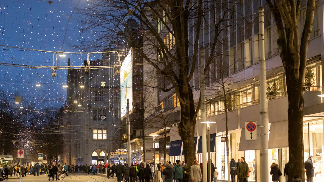 People walk under Christmas illuminations on Bahnhofstrasse shopping street in Zurich